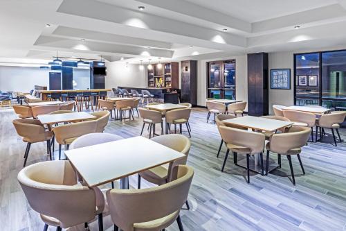 a dining room with tables and chairs and windows at Holiday Inn & Suites Stillwater-University West by IHG in Stillwater