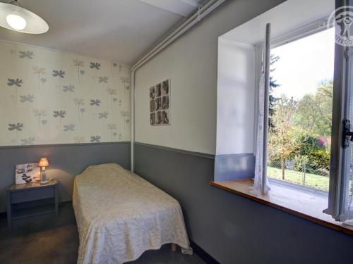 Schlafzimmer mit einem Bett und einem Fenster in der Unterkunft Gîte Saint-Symphorien-de-Lay, 3 pièces, 4 personnes - FR-1-496-278 in Saint-Symphorien-de-Lay