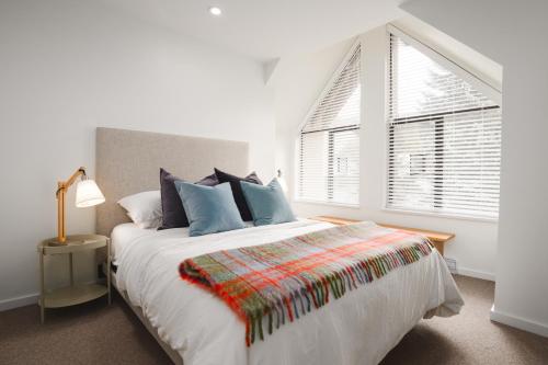 a white bedroom with a large bed and a window at The Blackcomb Ski-In Getaway in Whistler