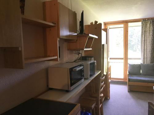une cuisine avec un four micro-ondes sur un comptoir et une fenêtre dans l'établissement Studio lumineux 4 pers, proche pistes, balcon sud - FR-1-346-572, à Bourg-Saint-Maurice