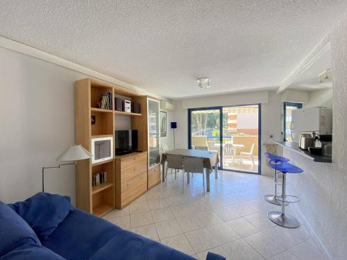 un salon avec un canapé bleu et une table dans l'établissement Appartement climatisé avec terrasse, proche plage et commerces, parking inclus, WiFi, classé 3* - FR-1-100-332, à Cavalaire-sur-Mer