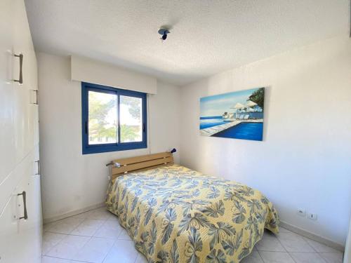 une chambre avec un lit dans une pièce avec une fenêtre dans l'établissement Appartement climatisé avec terrasse, proche plage et commerces, parking inclus, WiFi, classé 3* - FR-1-100-332, à Cavalaire-sur-Mer