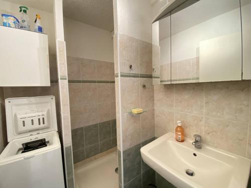 La petite salle de bains est pourvue d'un lavabo et d'un lavabo blanc. dans l'établissement Appartement climatisé avec terrasse, proche plage et commerces, parking inclus, WiFi, classé 3* - FR-1-100-332, à Cavalaire-sur-Mer