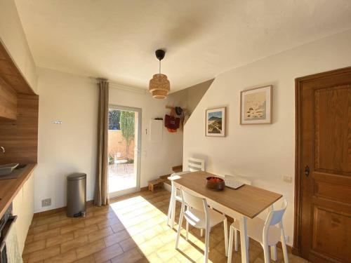 une cuisine et une salle à manger avec une table et des chaises dans l'établissement Mazet rénové avec piscine, tennis, 2 terrasses à Cavalaire-sur-Mer. - FR-1-100-333, à Cavalaire-sur-Mer