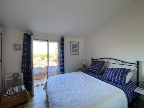 une chambre avec un lit et un balcon dans l'établissement Mazet rénové avec piscine, tennis, 2 terrasses à Cavalaire-sur-Mer. - FR-1-100-333, à Cavalaire-sur-Mer