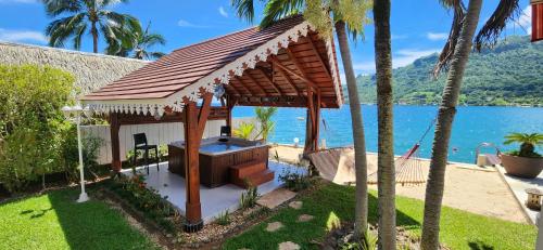 a gazebo in a yard next to the water at Villa Oramarama in Paopao