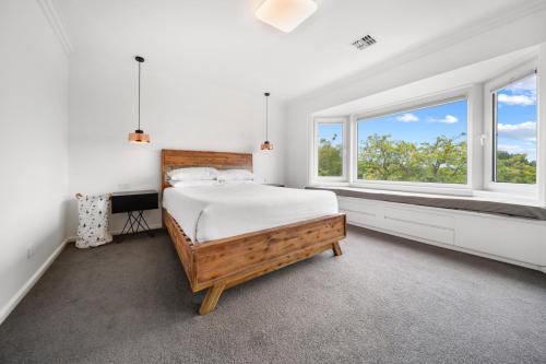 ein weißes Schlafzimmer mit einem Bett und zwei Fenstern in der Unterkunft 4-Bed Family Home with Spacious Backyard and BBQ in Lyons