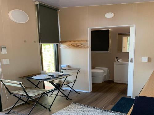 a room with a table and chairs and a bathroom at Cardwell by the Sea in Cardwell