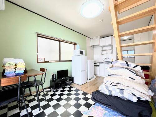Habitación con cocina con mesa y nevera. en House Kadoi201, en Tokio