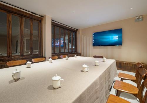 a conference room with a table and chairs and a tv at Lingxi Riverview Boutique Homestay - Phoenix Ancient Town in Fenghuang