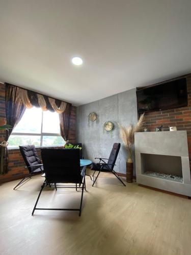 a living room with chairs and a fireplace at Apartamento en Retiro in El Retiro