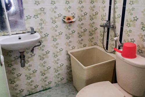 a small bathroom with a toilet and a sink at RedDoorz Syariah At Penginapan Sederhana Palembang in Palembang