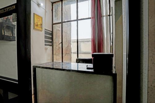 a glass table in a room with a window at Super Hotel O Krishna Guest House & PG in Ludhiana