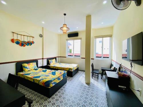 ein Wohnzimmer mit 2 Betten und einem Sofa in der Unterkunft SAM HOMESTAY HUE in Hue