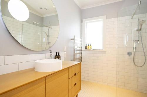 a bathroom with a sink and a mirror at Stags Head Cottage-cosy cottage with hot tub in Arrowtown