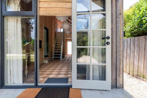 an open door to a house with a porch at Rustic Barn by the Bay in Low Head