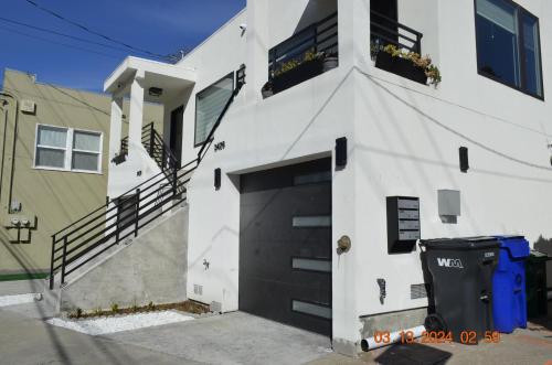 a white house with a black garage at Dimond Abode Vacation Home #2 Oakland Dimond District in Oakland