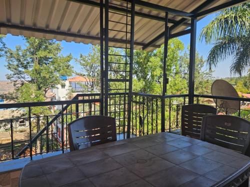 a patio with a table and chairs on a balcony at Seven Villa with Swimming pool in Panchgani