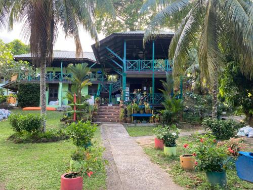 una casa azul con palmeras delante en Nazri's Place 2 en Tioman Island