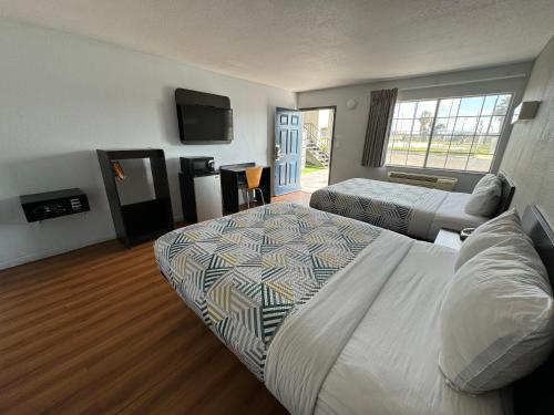 a hotel room with two beds and a flat screen tv at Motel 6-Delano, CA in Delano