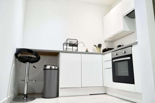 a kitchen with white cabinets and a trash can at Dream Retreat Luxury Apartment with Super King Bed, Pool Table PS4 - Sleeps 5 Free Parking in Bradford