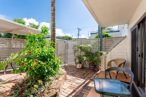 a patio with a chair and some plants at Driftwood on the Beach in Yeppoon