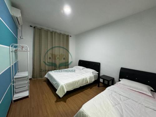 ein Schlafzimmer mit 2 Betten und einer Treppe darin in der Unterkunft Zayyan Guesthouse in Kuching