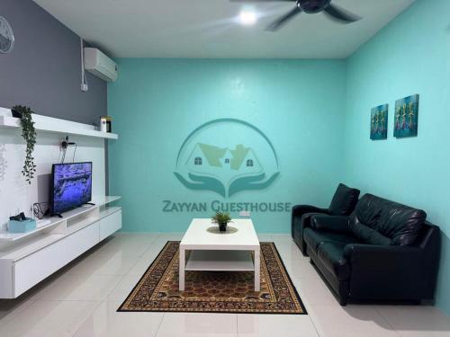 ein Wohnzimmer mit einem Sofa und einem Tisch in der Unterkunft Zayyan Guesthouse in Kuching