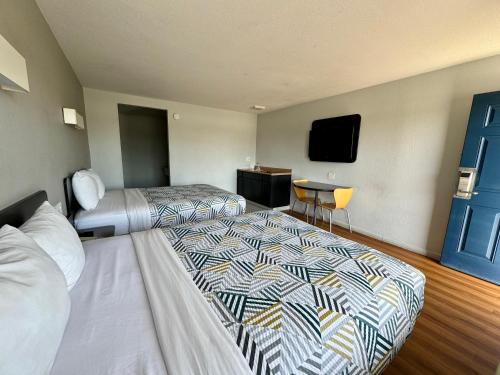 a hotel room with two beds and a flat screen tv at Motel 6-Delano, CA in Delano