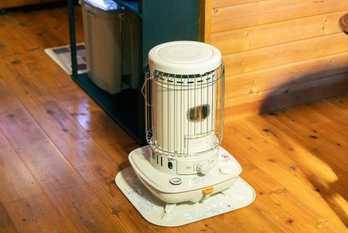 a white blender sitting on a wooden floor at 千葉の静かな山の中の貸切コテージ 鴨川コテージ in Kamogawa