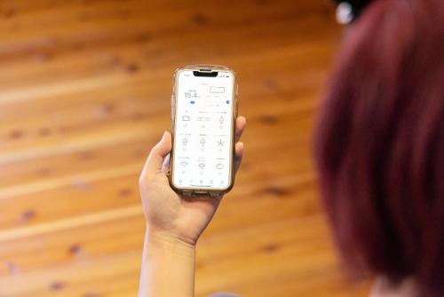 a person holding a remote control in their hand at 千葉の静かな山の中の貸切コテージ 鴨川コテージ in Kamogawa