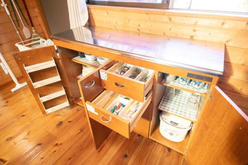 a small kitchen with an open cabinet in a room at 千葉の静かな山の中の貸切コテージ 鴨川コテージ in Kamogawa
