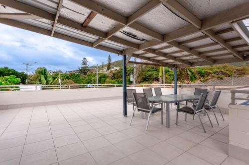 an outdoor patio with a table and chairs at Driftwood on the Beach in Yeppoon