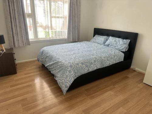 a bedroom with a bed with a blue comforter at One bedroom entire unit in Christchurch