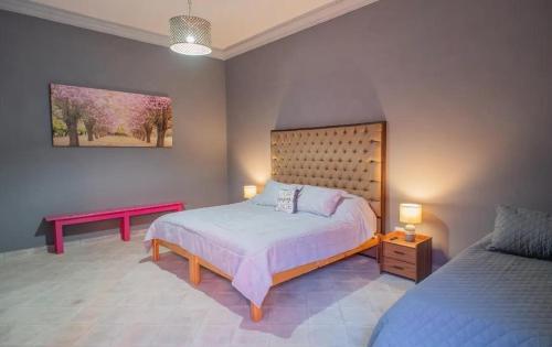 サンミゲル・デ・アジェンデにあるCasa Allegriaのベッドルーム(ベッド1台、ベンチ付)