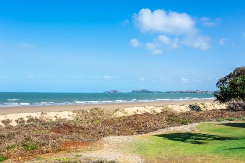 a sandy beach with the ocean in the background at Driftwood on the Beach in Yeppoon