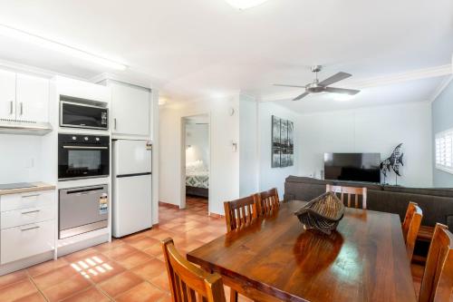 a kitchen and dining room with a table and a couch at Driftwood on the Beach in Yeppoon
