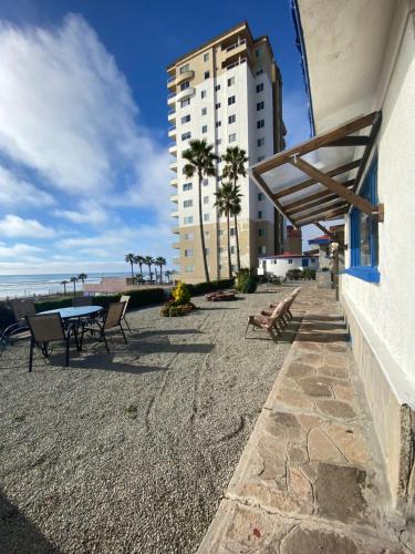 a building with a table and chairs on the beach at Rosarito By The Sea in Rosarito