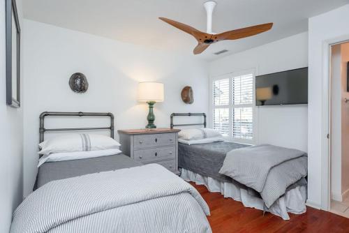 a bedroom with two beds and a ceiling fan at 478 Oceanwoods Cottage Lagoon View in Kiawah Island
