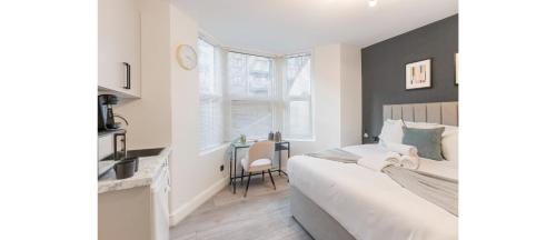 a bedroom with a bed and a desk in it at Sleek Cityscape: Modern Studio with Kitchenette in London