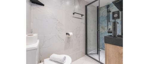 a bathroom with a toilet and a glass shower at Sleek Cityscape: Modern Studio with Kitchenette in London