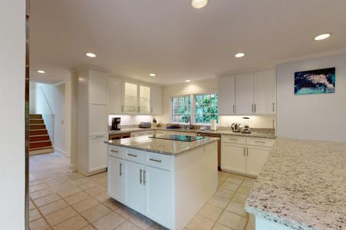 a kitchen with white cabinets and granite counter tops at 81 Surfsong Rd in Kiawah Island