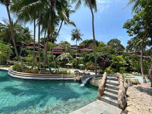ノンガサにあるNongsa Village Peaceful Villa in private beach Resortのヤシの木が茂るリゾートのプール