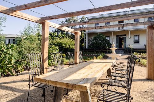 a wooden table and chairs under a pergola at Eagles Nest Milton in Milton