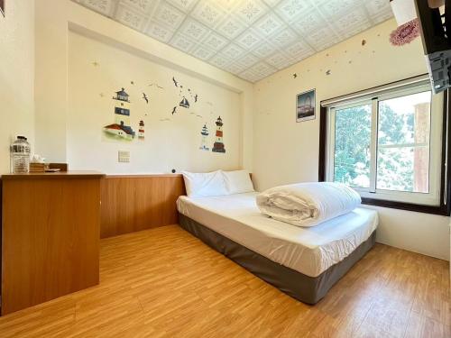 a bedroom with a bed and a window at Deep Forest Inn in Fenchihu