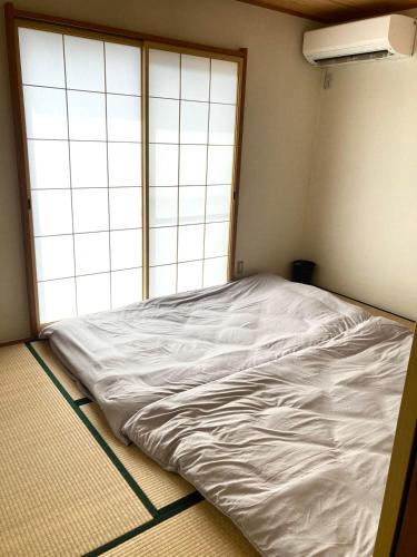 a large white bed in a room with a window at Maison Petit Lapin メゾンプチラパン in Karuizawa