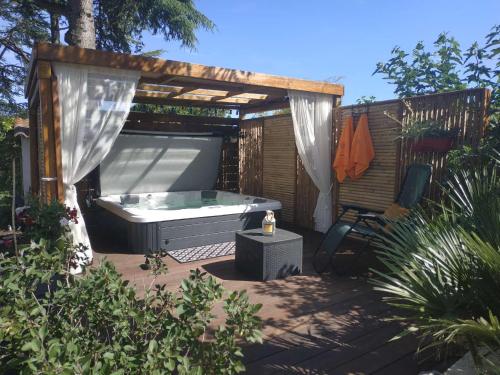 Un bain à remous est installé sous une pergola. dans l'établissement VILLA NATURISTE JO&SPA ANNA'BELLA Luxury Suites "naturist couples only", au Cap d'Agde