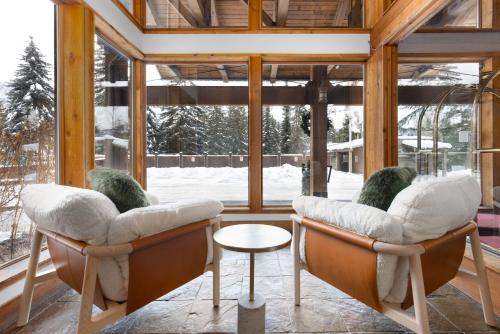 a room with two chairs in front of a window at Tantalus Resort Lodge in Whistler