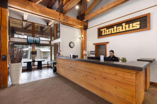 a man sitting at the bar of a restaurant at Tantalus Resort Lodge in Whistler