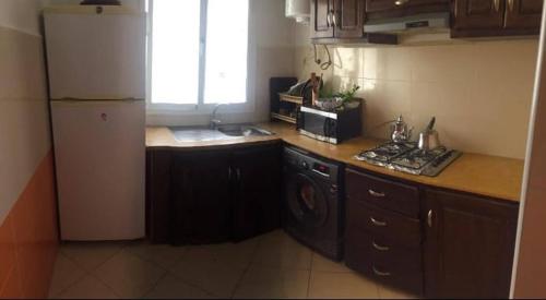 a kitchen with a white refrigerator and a counter top at apparemment à louer pour les familles in Meknès